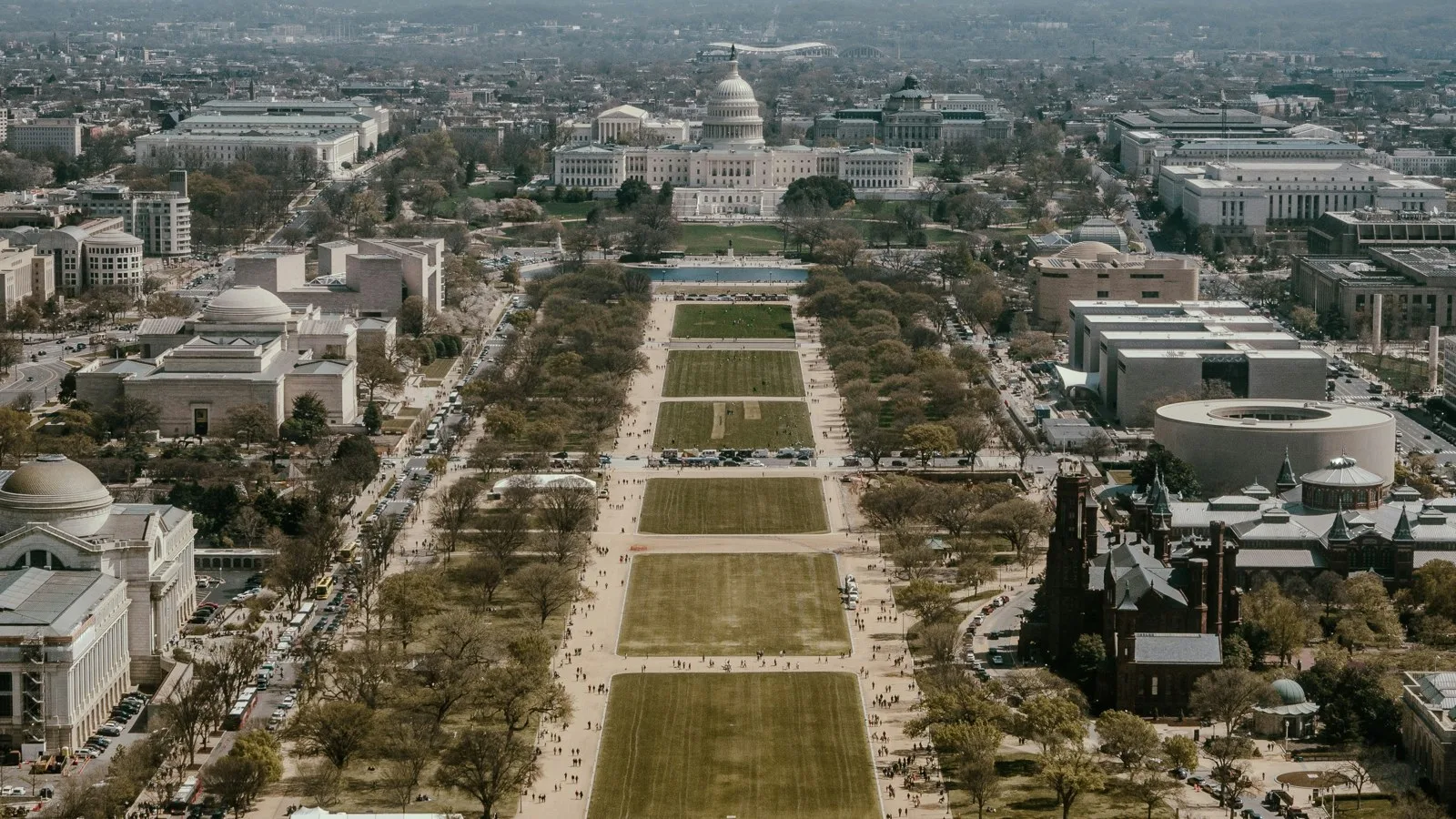 Aerial view of the National Mall in Washington looking toward the US Capitol, with museums and tree-lined lawns on both sides